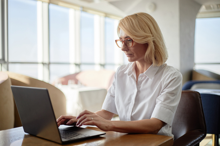 Vrouw zit achter haar laptop te werken