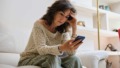 Piekerende vrouw met telefoon