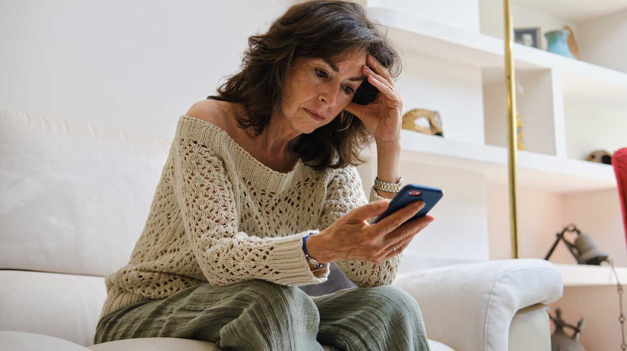 Piekerende vrouw met telefoon