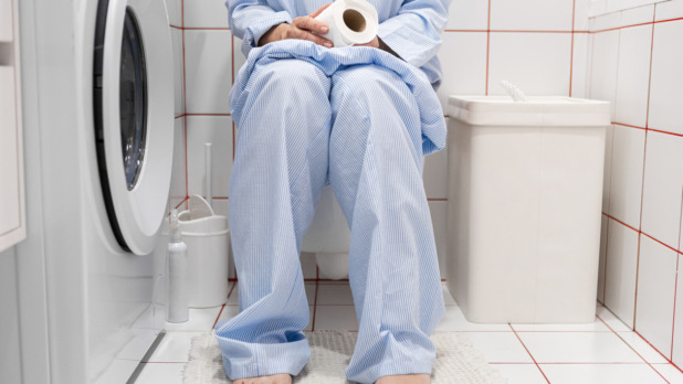 vrouw in pyjama op de wc