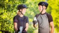 Man en een vrouw met fietshelm op de fiets tijdens fietstocht