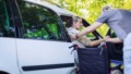 Man helpt gehandicapte vrouw uit auto