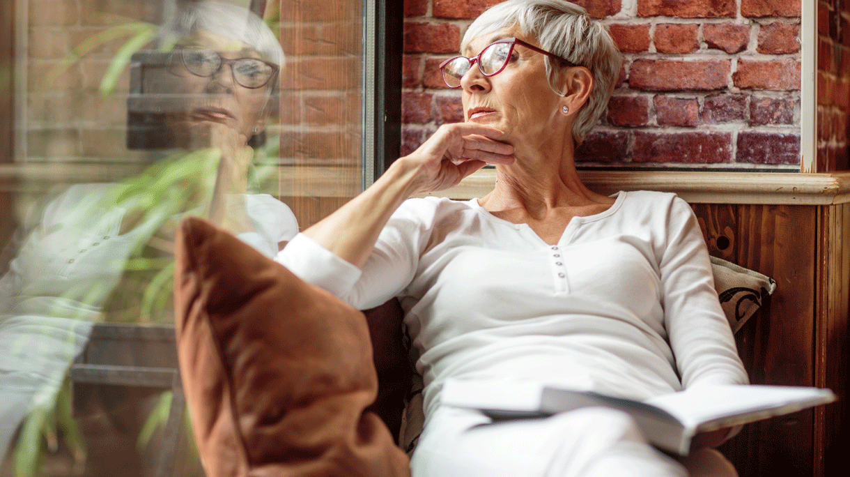 Vrouw met boek achter vensterraam