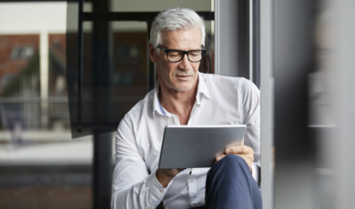Oudere man in de weer met zijn tablet