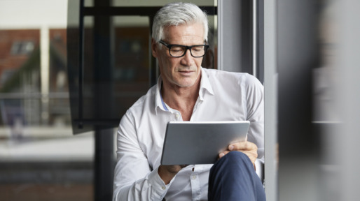 Oudere man in de weer met zijn tablet