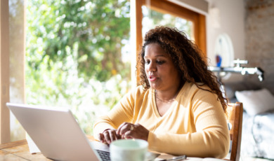 Vrouw zit achter haar laptop te werken