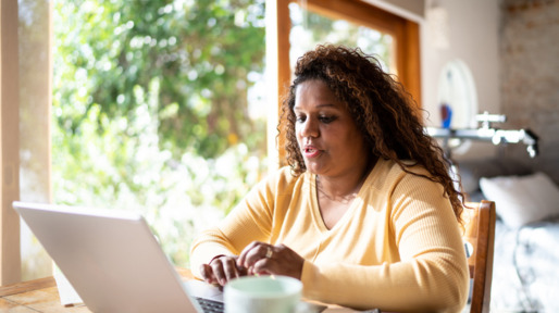 Vrouw zit achter haar laptop te werken