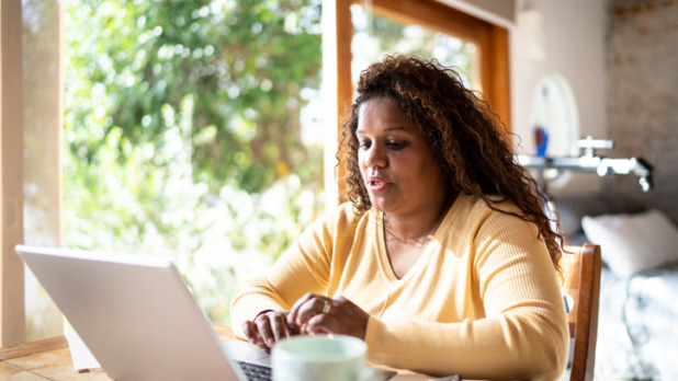 Vrouw zit achter haar laptop te werken