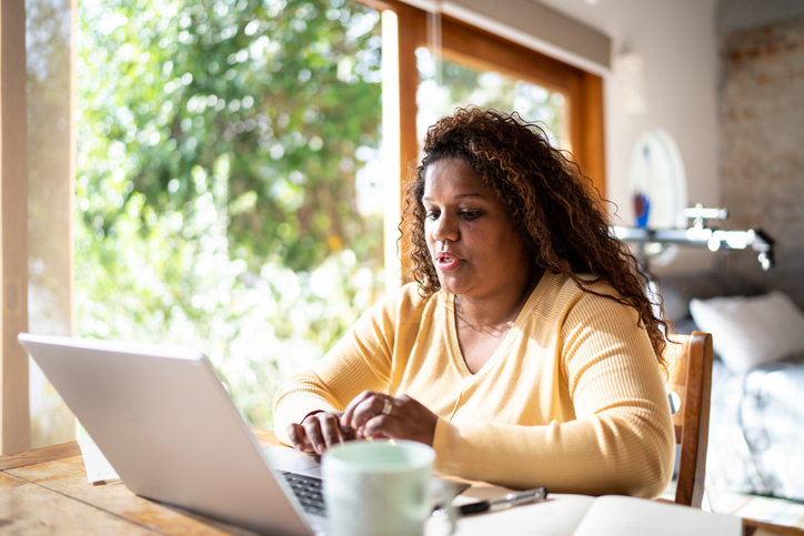 Vrouw zit achter haar laptop te werken