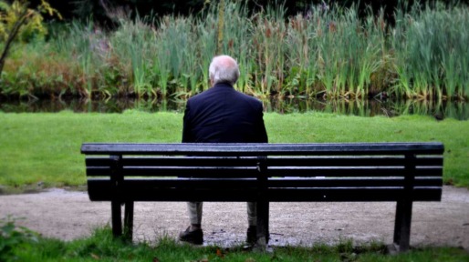 Eenzame man buiten op bankje