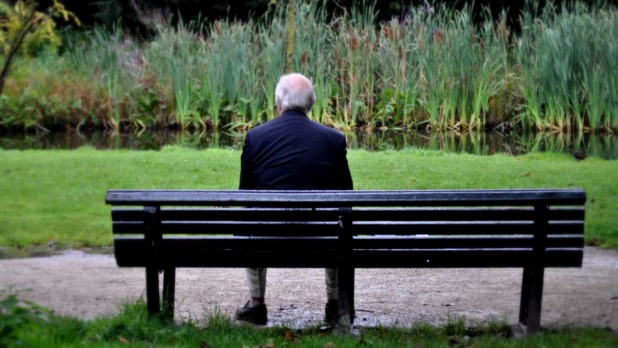 Eenzame man buiten op bankje