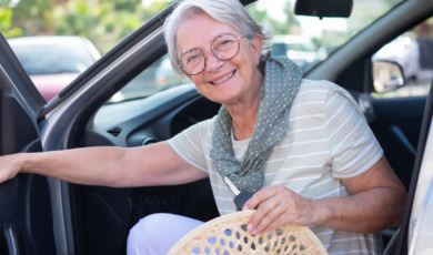 oudere vrouw stapt in auto op zomerse dag