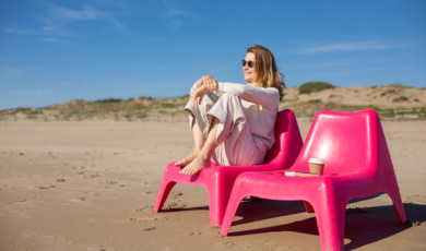 Vrouw op roze strandstoel