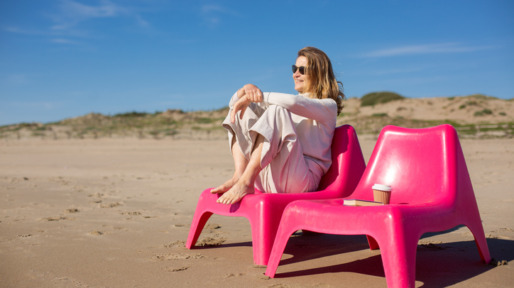 Vrouw op roze strandstoel