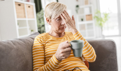 oudere vrouw zit moe op de bank