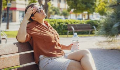 oudere vrouw bijkomen op bankje in zomer