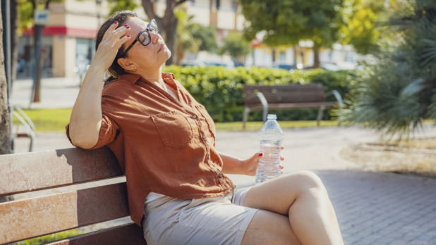 oudere vrouw bijkomen op bankje in zomer