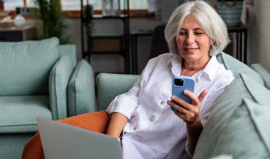 oudere vrouw aan de telefoon met laptop