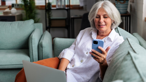 oudere vrouw aan de telefoon met laptop