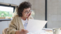 oudere verdrietige vrouw op laptop