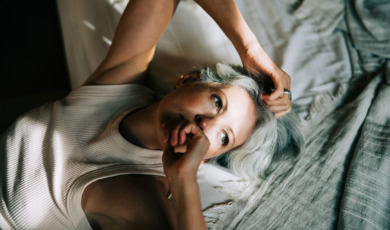 Vrouw ligt op bed en voelt zich niet goed
