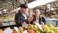 Ouder echtpaar op indoor markt bij groenten