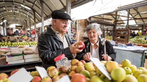 Ouder echtpaar op indoor markt bij groenten