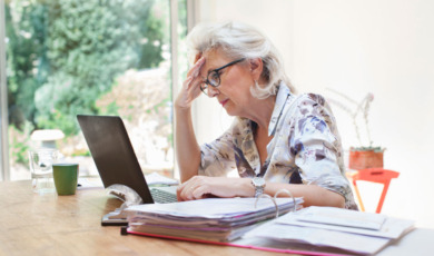 Vrouw zorgelijk achter een laptop