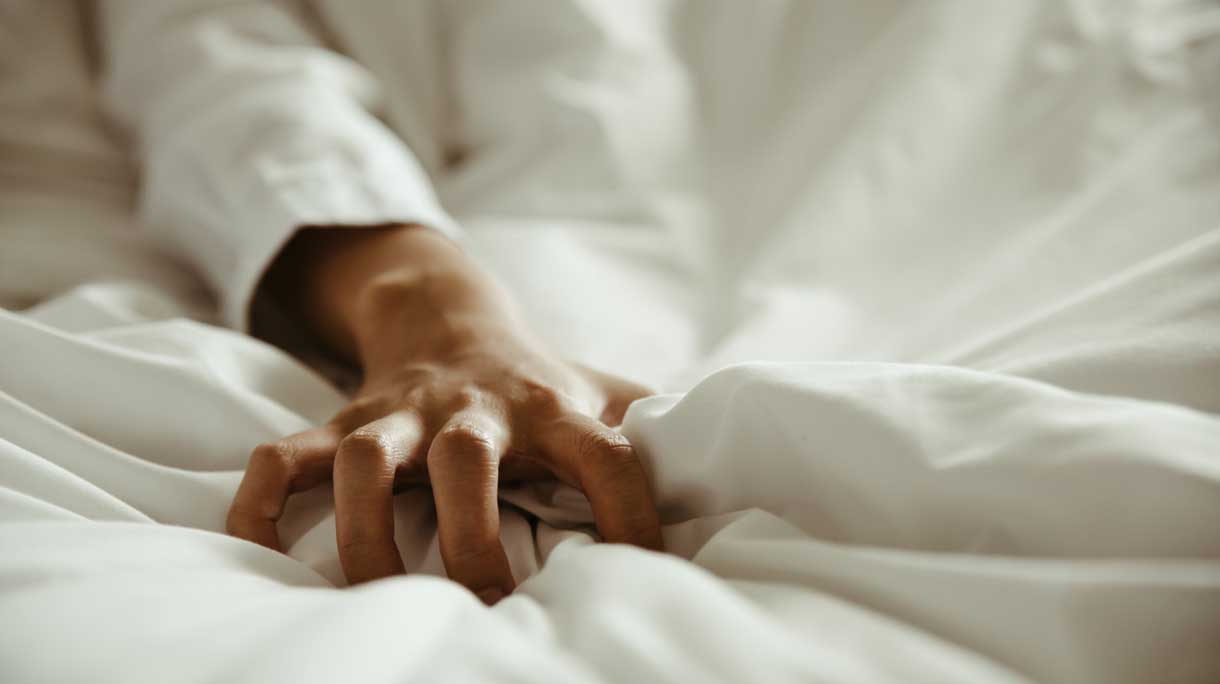 Hand verkrampt op bed