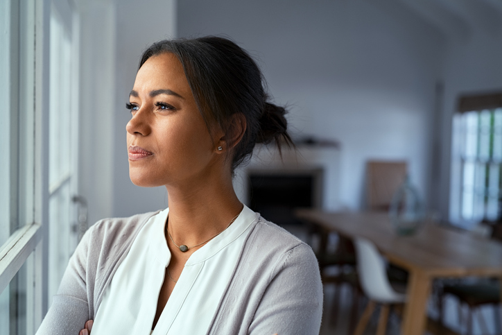 Vrouw kijkt bedachtzaam uit het raam