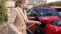 Electrisch rijden, vrouw laadt haar ecar op