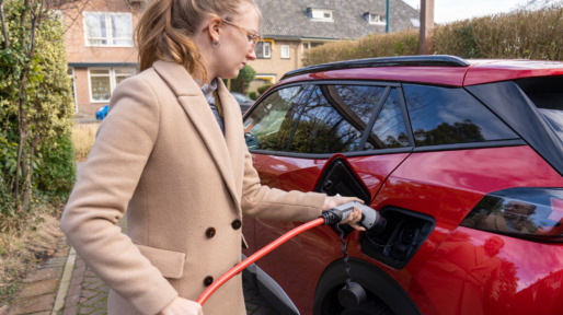 Electrisch rijden, vrouw laadt haar ecar op
