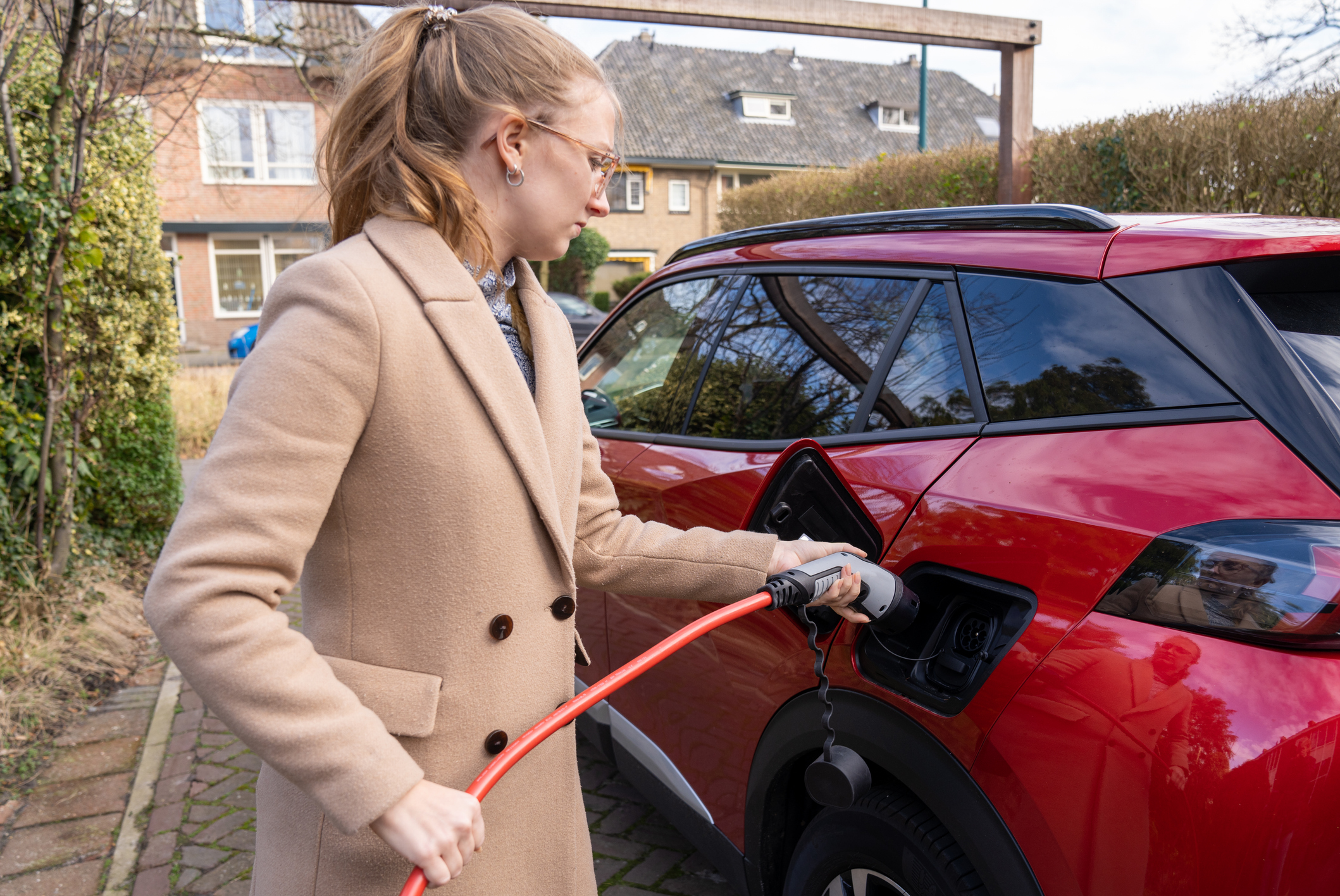 Electrisch rijden, vrouw laadt haar ecar op