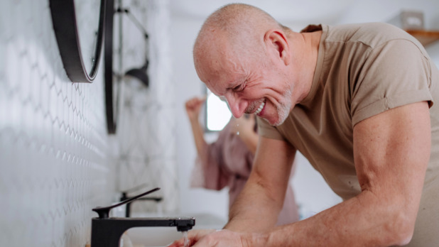 senior man met zwarte kraan