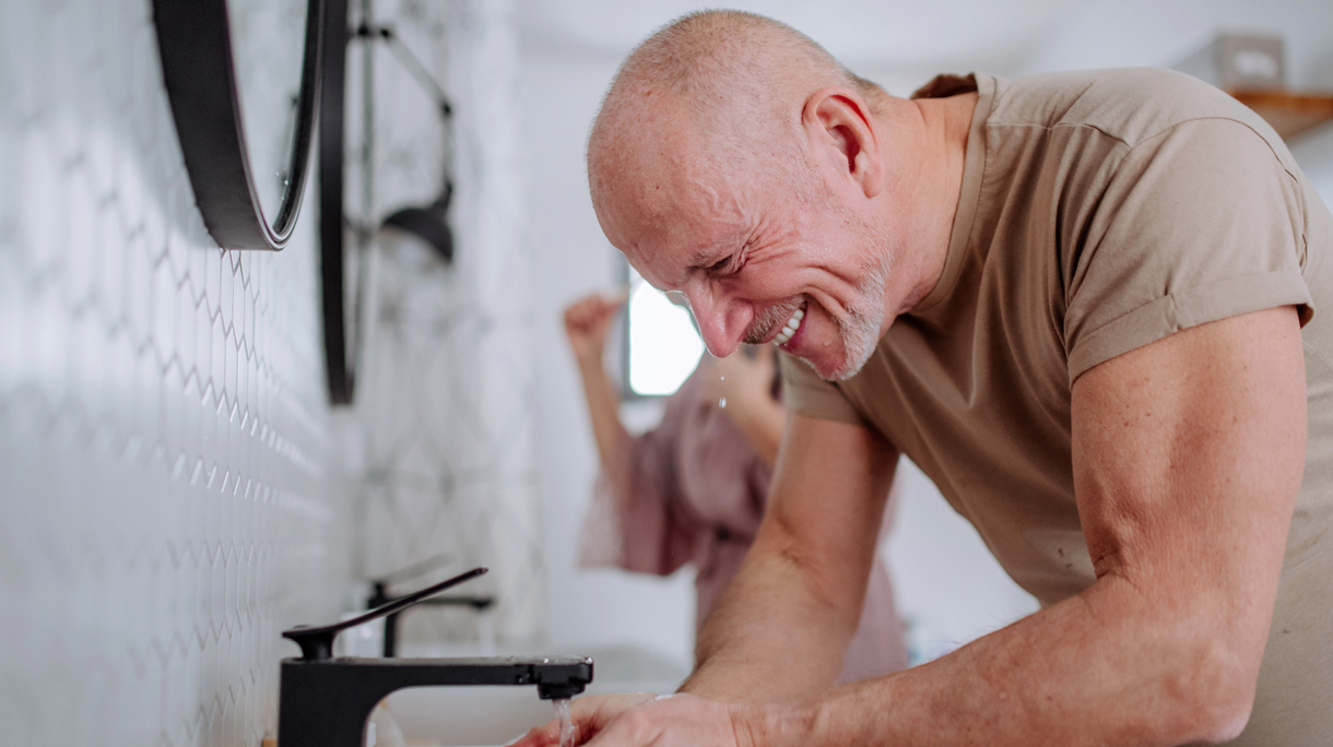 senior man met zwarte kraan