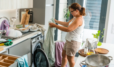 Vrouw in rommelige keuken zoekt de was uit