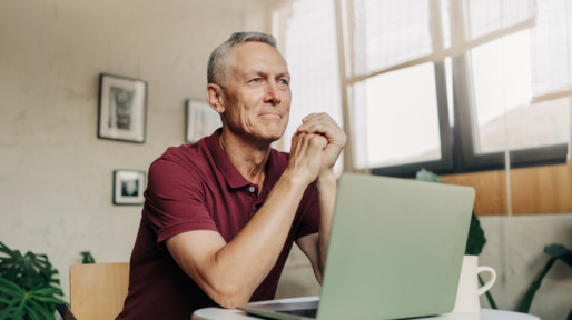 Man zit peinzend achter zijn laptop