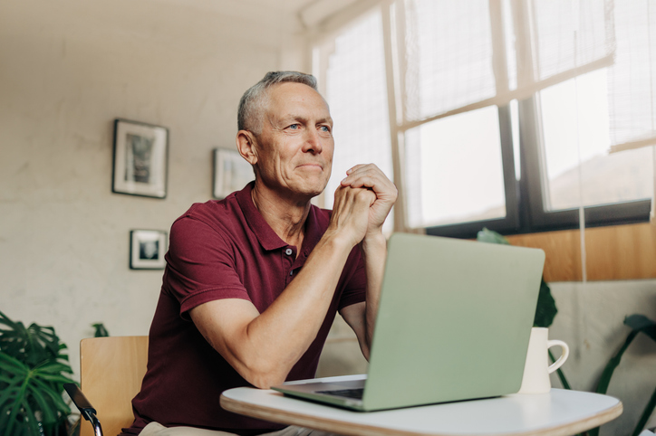Man zit peinzend achter zijn laptop