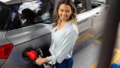 Vrouw is bezig met haar benzinetank vol te tanken bij tankstation