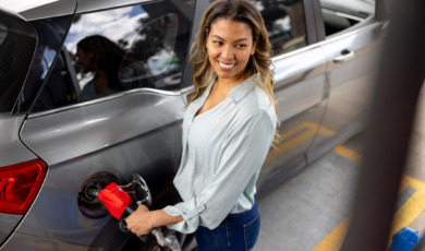 Vrouw is bezig met haar benzinetank vol te tanken bij tankstation