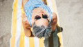 oudere vrouw met zonnebril op strand