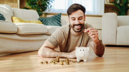 Man stopt geld in zijn spaarvarken