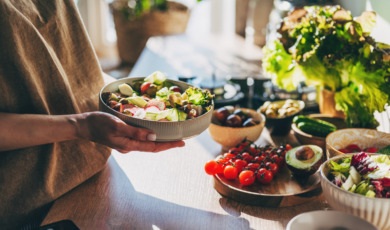 Vrouw met een bakje salade in haar hand, gezond eten