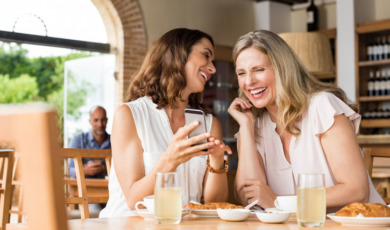 Vriendinnen lachend aan tafel
