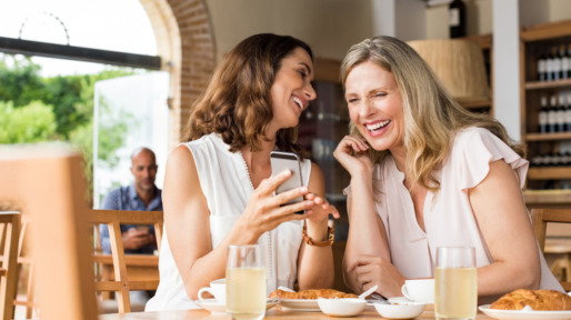 Vriendinnen lachend aan tafel