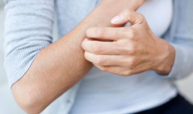 Vrouw krabt aan haar arm