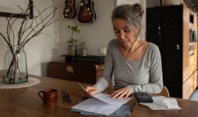 vrouw aan tafel controleert recht op toeslagen aow