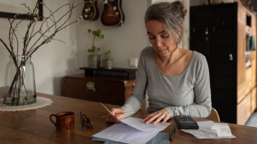 vrouw aan tafel controleert recht op toeslagen aow