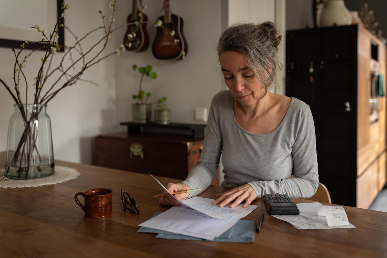 vrouw aan tafel controleert recht op toeslagen aow