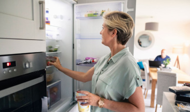 Vrouw haalt eten uit de koelkast